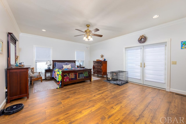 bedroom featuring ornamental molding, wood finished floors, visible vents, and access to exterior