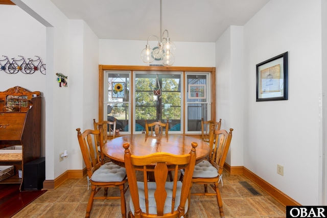 dining room featuring a chandelier, visible vents, and baseboards