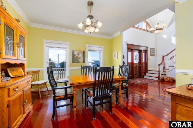 dining room featuring wood finished floors, a notable chandelier, and stairs