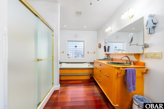 bathroom featuring a stall shower, visible vents, wood finished floors, a garden tub, and recessed lighting