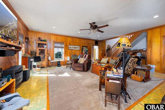 living room with ornamental molding, stairway, and wooden walls