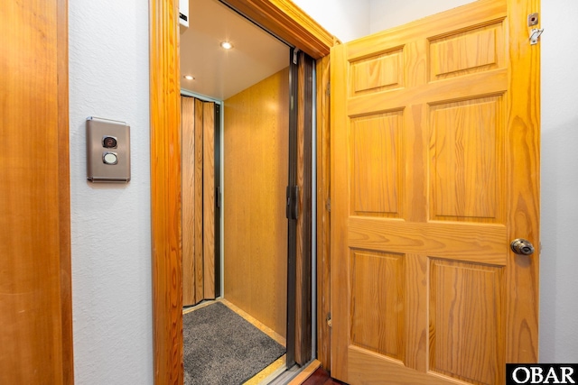 interior space featuring carpet floors and a textured wall