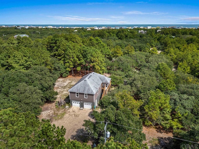 drone / aerial view featuring a water view and a forest view