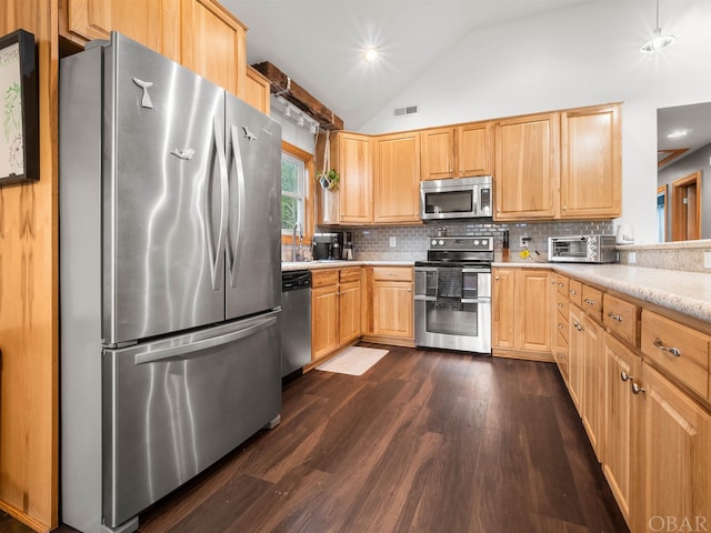 kitchen with visible vents, dark wood-style floors, vaulted ceiling, stainless steel appliances, and light countertops