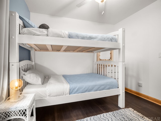 bedroom with dark wood-style flooring, a ceiling fan, and baseboards