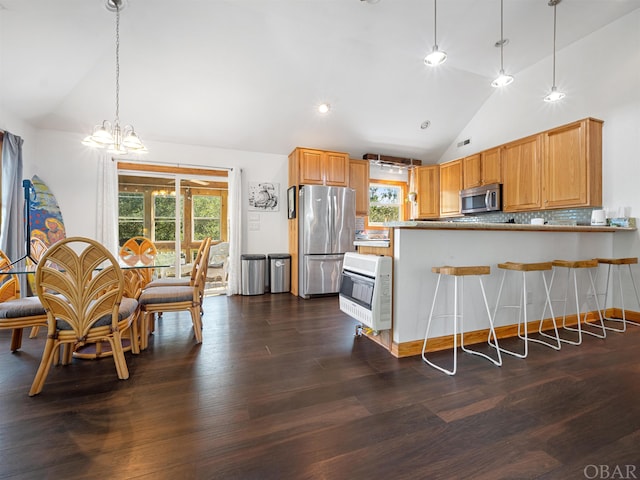 kitchen featuring stainless steel appliances, a peninsula, dark wood-style flooring, light countertops, and heating unit