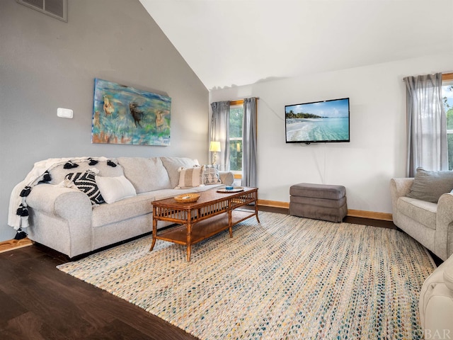 living room featuring lofted ceiling, baseboards, visible vents, and wood finished floors