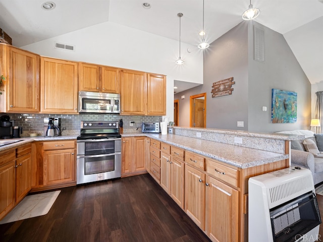 kitchen with visible vents, appliances with stainless steel finishes, open floor plan, heating unit, and a peninsula