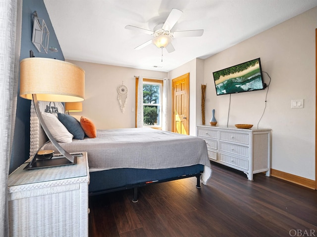 bedroom with dark wood-style flooring, a ceiling fan, and baseboards