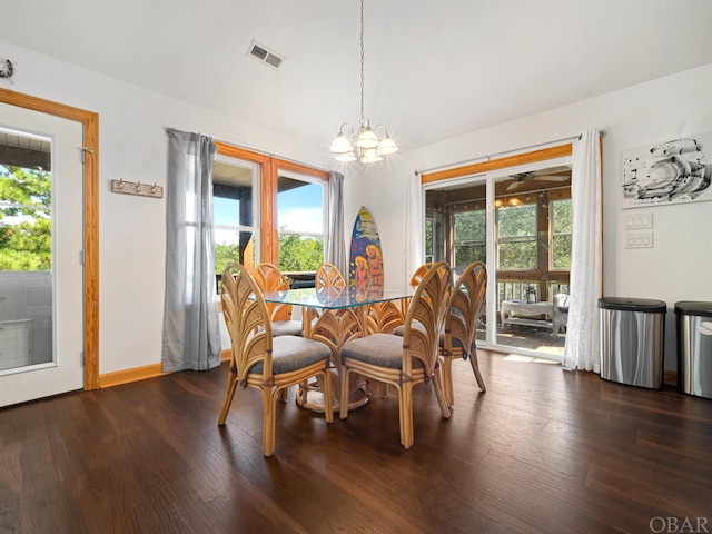 dining space with visible vents, dark wood finished floors, a notable chandelier, and baseboards