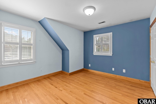 bonus room featuring light wood-style flooring, plenty of natural light, visible vents, and baseboards