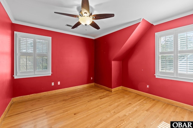 additional living space with a ceiling fan, wood finished floors, visible vents, and baseboards