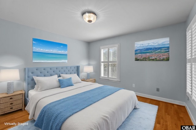 bedroom featuring baseboards and wood finished floors