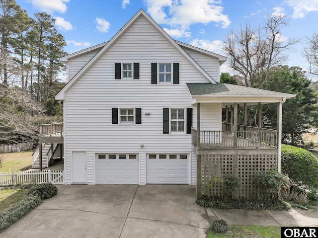 view of front facade featuring a garage, roof with shingles, stairs, fence, and a deck