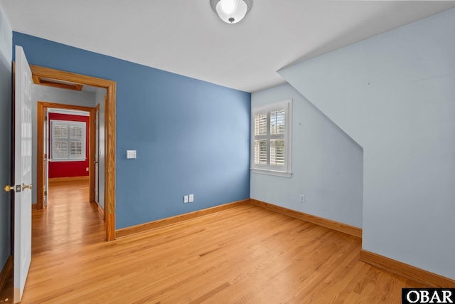 bonus room with light wood-style floors and baseboards