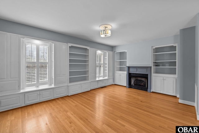 unfurnished living room featuring a fireplace and light wood finished floors