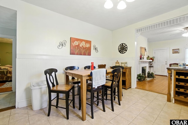 401 E Queen St, Edenton, NC 27932 - dining space featuring a wainscoted wall, tile patterned floors, a fireplace, and ceiling fan
