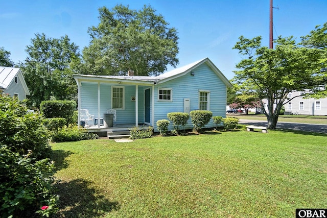 401 E Queen St, Edenton, NC 27932 - view of front facade with covered porch, a front yard, and a chimney