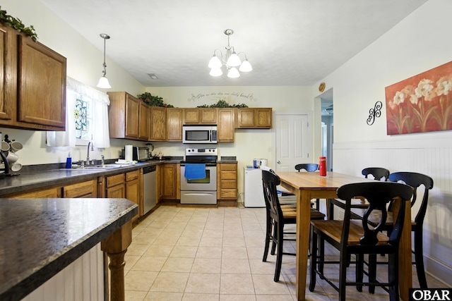 401 E Queen St, Edenton, NC 27932 - kitchen with appliances with stainless steel finishes, brown cabinets, dark countertops, a chandelier, and pendant lighting