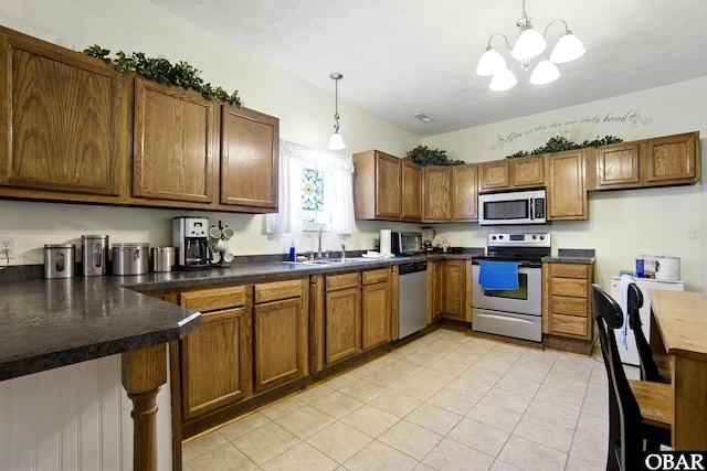 401 E Queen St, Edenton, NC 27932 - kitchen featuring stainless steel appliances, brown cabinets, hanging light fixtures, a chandelier, and dark countertops