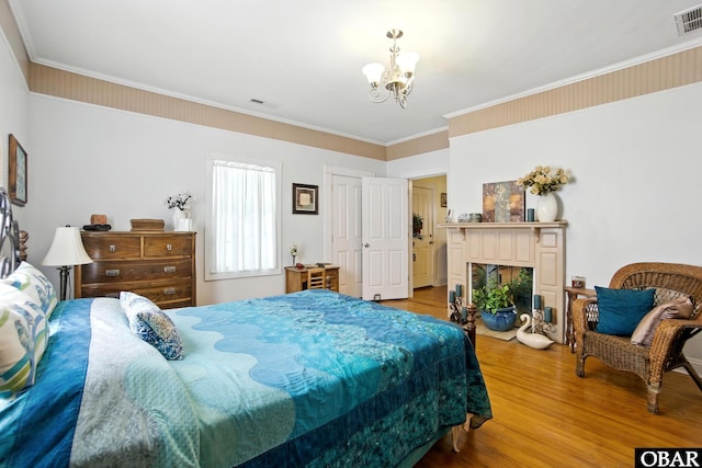 401 E Queen St, Edenton, NC 27932 - bedroom featuring a chandelier, wood finished floors, ornamental molding, and a fireplace with flush hearth