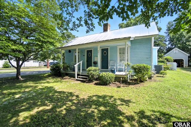 401 E Queen St, Edenton, NC 27932 - view of front facade featuring a chimney, covered porch, a front yard, and a metal roof