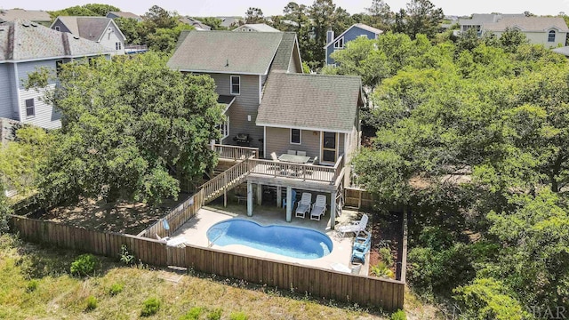 view of pool with a patio, a fenced backyard, a residential view, stairway, and a wooden deck