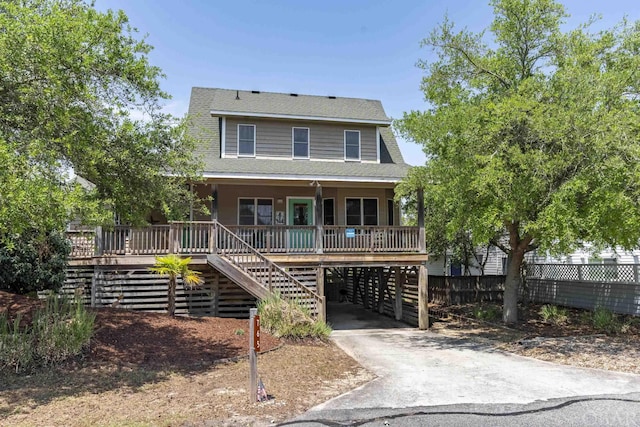 view of front of property with a carport, a porch, a shingled roof, and driveway