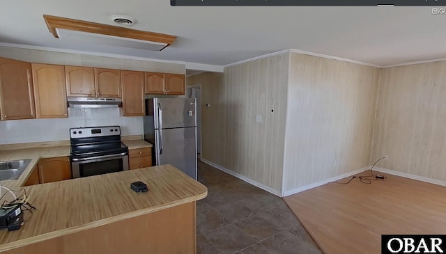 kitchen with appliances with stainless steel finishes, under cabinet range hood, light countertops, a sink, and crown molding