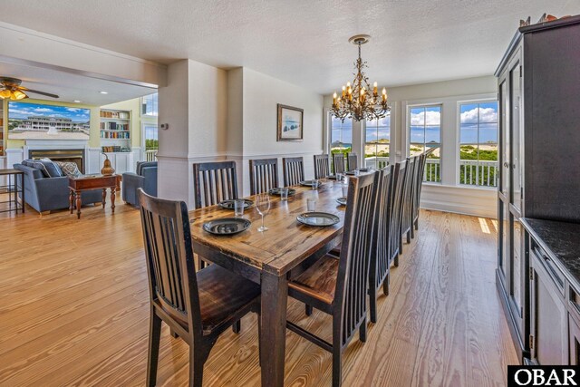 1459 Ocean Pearl Rd Lot 2, 3A, 3B, Corolla, NC 27927 - dining space with light wood-type flooring, a chandelier, a fireplace, ceiling fan, and a textured ceiling