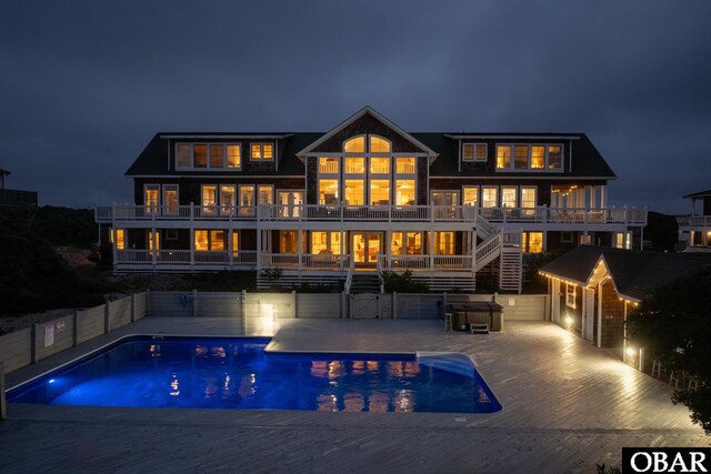 1459 Ocean Pearl Rd Lot 2, 3A, 3B, Corolla, NC 27927 - back of house at night featuring an outdoor pool, a balcony, and stairway
