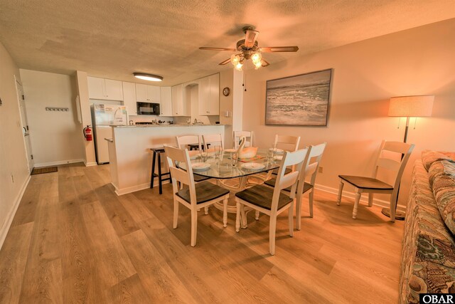 24256 Resort Rodanthe Dr Unit 6B, Rodanthe, NC 27968 - dining room with a ceiling fan, light wood-type flooring, a textured ceiling, and baseboards