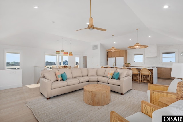 living room with visible vents, ceiling fan, vaulted ceiling, light wood-type flooring, and recessed lighting