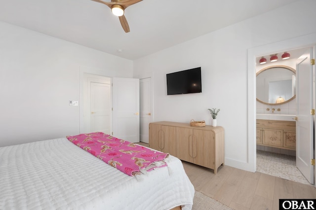 bedroom featuring light wood-type flooring, ensuite bath, and a ceiling fan