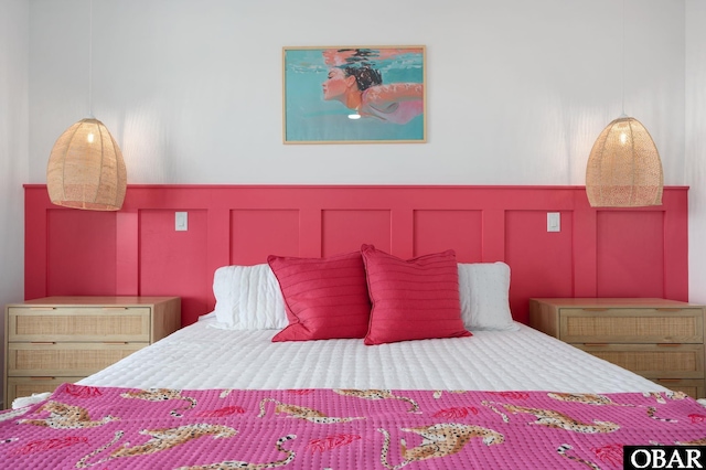 bedroom with wainscoting and a decorative wall