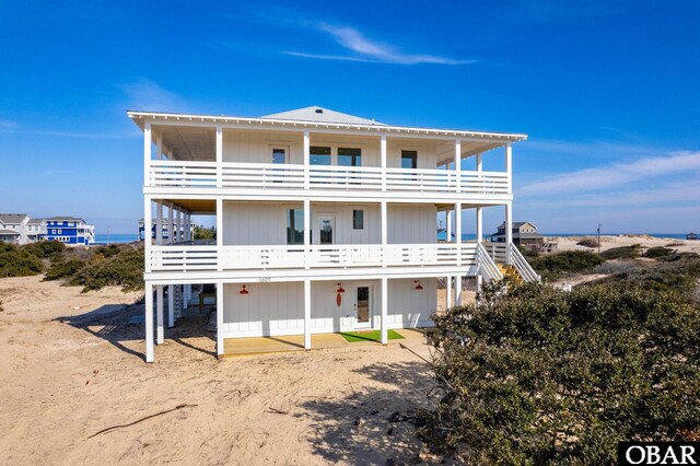 rear view of house featuring a balcony and stairs