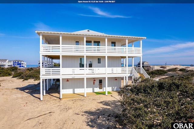 rear view of property with a balcony and stairway