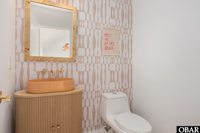 bathroom featuring toilet, tile walls, and vanity