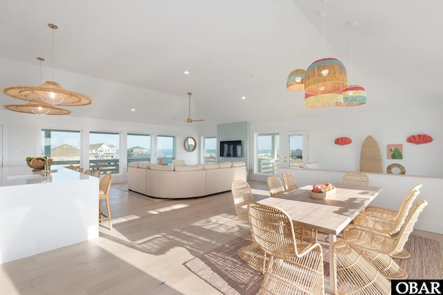 dining space with light wood finished floors, recessed lighting, and high vaulted ceiling