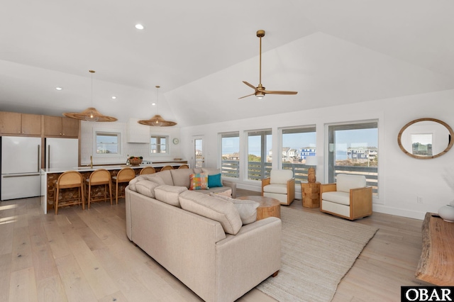 living area with recessed lighting, light wood-style floors, baseboards, and ceiling fan