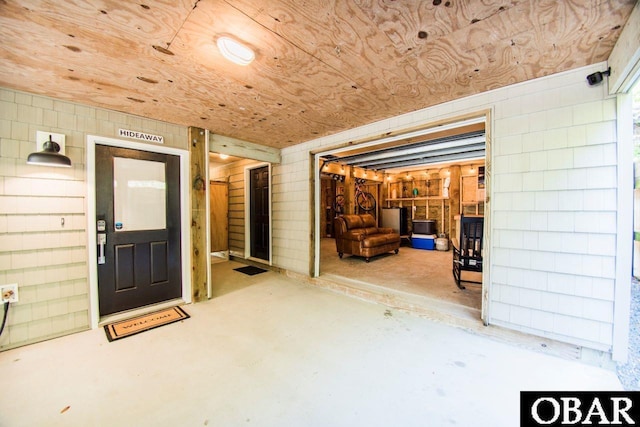 interior space featuring concrete block wall and wood ceiling