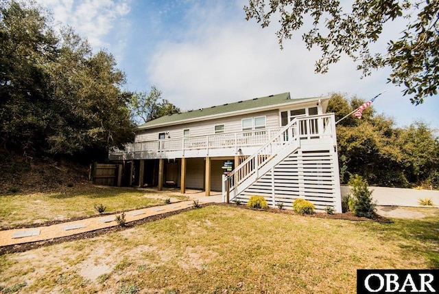 view of front facade with a deck, stairs, and a front lawn