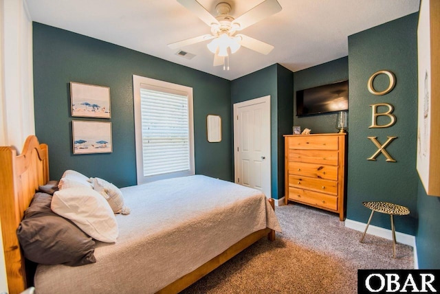 carpeted bedroom with a ceiling fan, visible vents, and baseboards