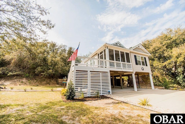 view of front facade featuring stairs, a carport, and a sunroom