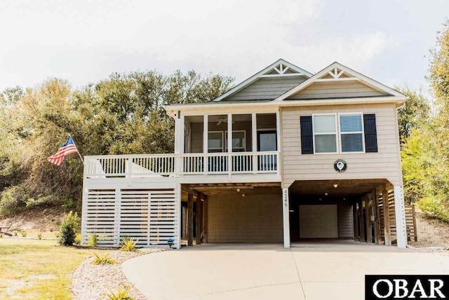 view of front of home with an attached garage, a sunroom, a carport, driveway, and stairs