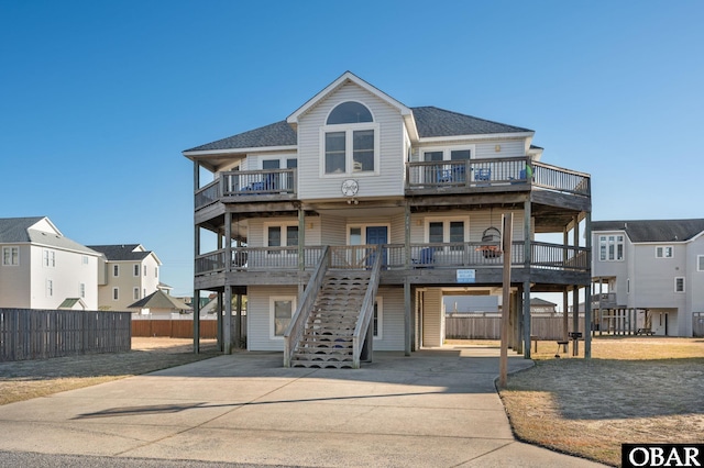 beach home with stairs, fence, and a residential view