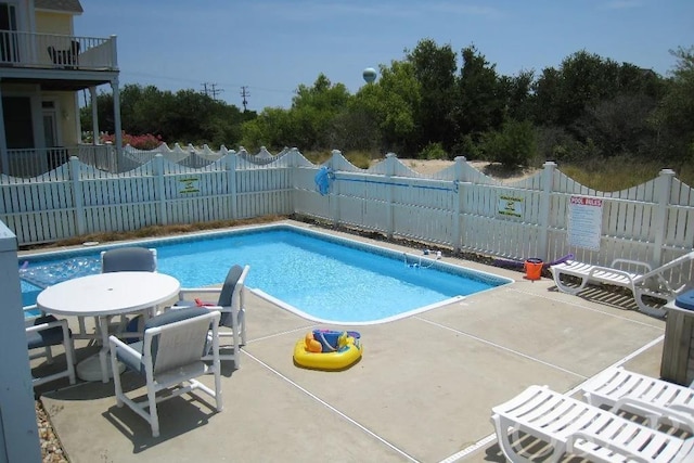 community pool featuring a patio area and a fenced backyard