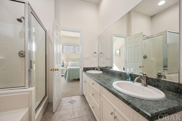 ensuite bathroom with a tile shower, tile patterned flooring, a sink, and connected bathroom