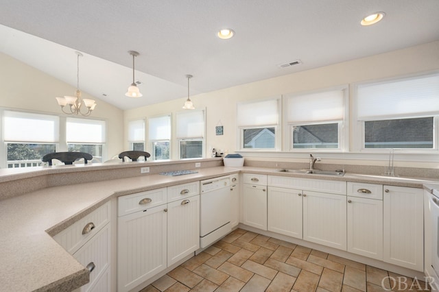 kitchen with pendant lighting, light countertops, open floor plan, white dishwasher, and a sink