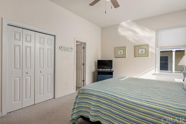 bedroom featuring a closet, light colored carpet, and ceiling fan